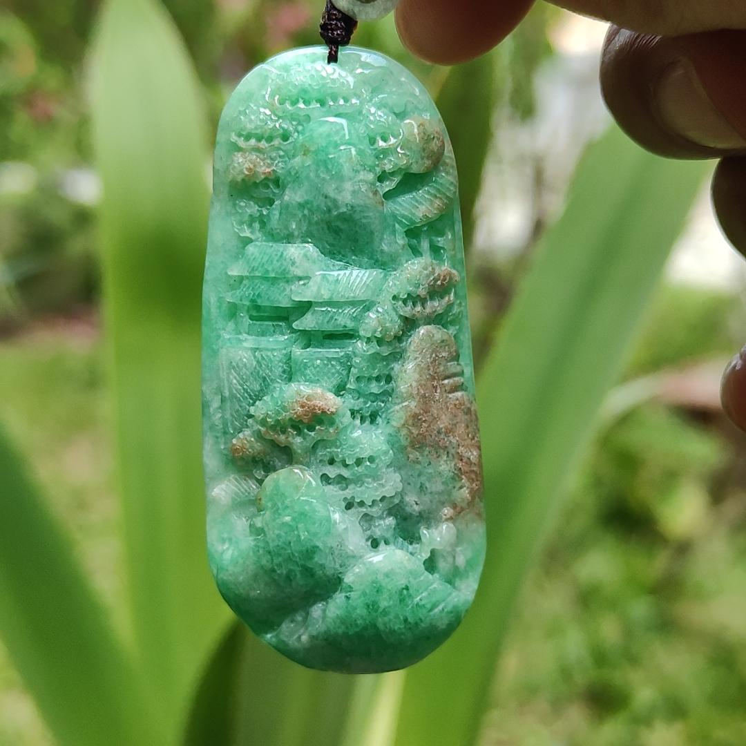 Green with patches of light brown Translucent Natural Type A Jadeite Pendant carved with scenery with NGI Gemstone report weight 126.07 grams, 60.73 * 27.79 * 9.53 mm , fine grain crystal aggregate, granular and fibrous interlocking texture (pendant142)