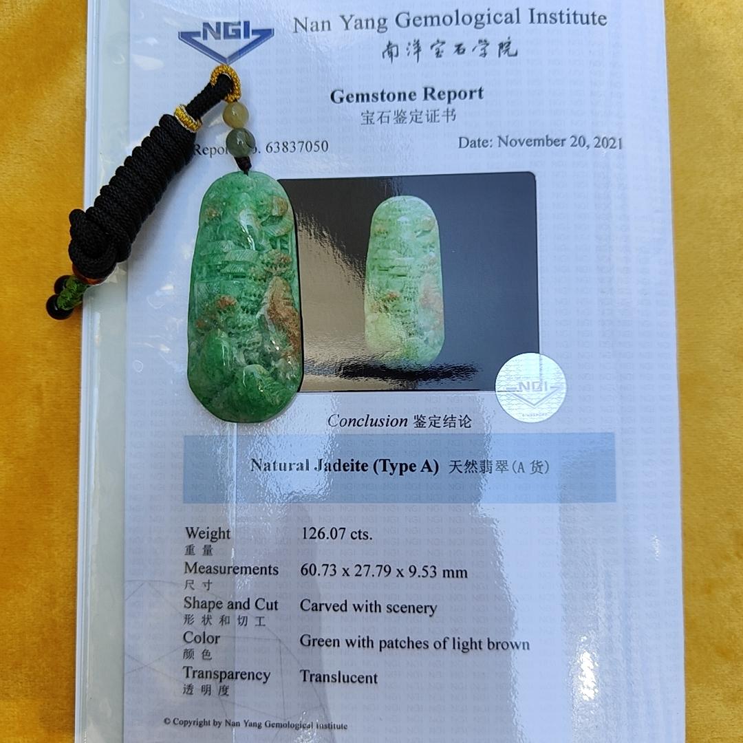 Green with patches of light brown Translucent Natural Type A Jadeite Pendant carved with scenery with NGI Gemstone report weight 126.07 grams, 60.73 * 27.79 * 9.53 mm , fine grain crystal aggregate, granular and fibrous interlocking texture (pendant142)